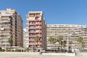 two tall buildings with palm trees in front of them at El Raco, A-8-16 in Cullera
