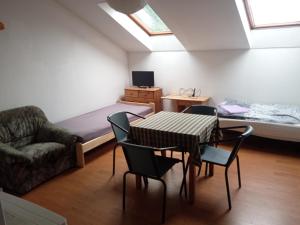 ジーチャニにあるPension Kozelのテーブル、椅子、ベッドが備わる客室です。