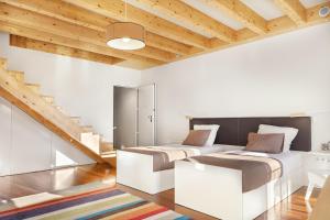 two beds in a room with wooden ceilings at ExtendALL in Porto
