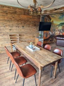 een eetkamer met een houten tafel en stoelen bij Western Cottage Hocheifel in Wirft