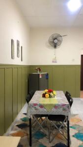 a room with a table with flowers on it at MZ Homestay in Kuala Rompin
