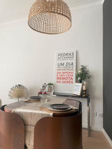 uma sala de jantar com uma mesa e um lustre em Lisboa T2 Portas de Benfica em Amadora