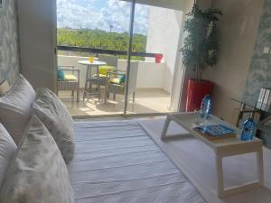 a living room with a couch and a table and a balcony at perfect 2 bedrooms 2 balconies pool and golf in Asilah