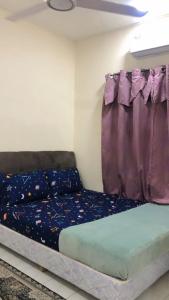Bett in einem Zimmer mit Fenster in der Unterkunft MZ Homestay in Kuala Rompin