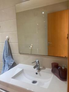 lavabo en el baño con un espejo grande encima. en lovely and chic Appartment in asilah marina golf en Asilah