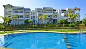 a large swimming pool in front of a building at perfect 2 bedrooms 2 balconies pool and golf in Asilah