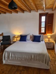 a bedroom with a large white bed with blue pillows at Studio 1 in Patmos
