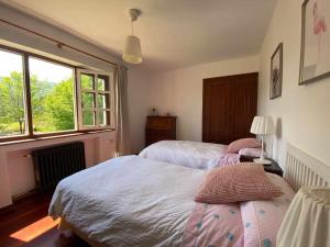 1 Schlafzimmer mit 2 Betten und einem Fenster in der Unterkunft Casa Vaqueiro Llanes in Llanes