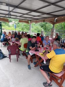 a group of people sitting at tables under a tent at Apartments Nino Skadar lake in Virpazar