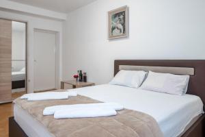 a bedroom with a large bed with two towels on it at Apartments Maxi Katić in Herceg-Novi