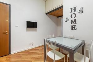 a glass table and chairs in a room with a tv at Easylife - Oasi urbana in zona Bocconi in Milan