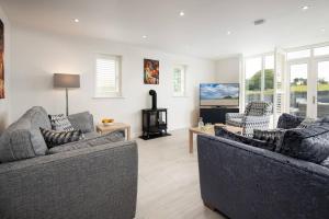 a living room with two couches and a fireplace at Sunset View, Hot Tub Haven for max 8 people in Chatton