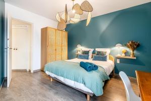een blauwe slaapkamer met een bed en een tafel bij Le Nani Raou par Dodo à Cassis in Cassis