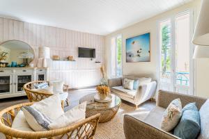 een woonkamer met een bank, stoelen en een tafel bij Le Nani Raou par Dodo à Cassis in Cassis