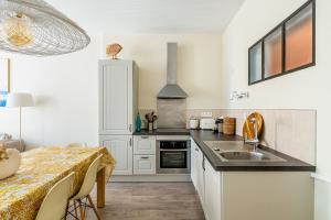 een keuken met een eettafel en een wastafel bij Le Nani Raou par Dodo à Cassis in Cassis +11 foto's
