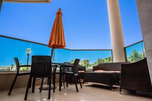 a patio with a table and chairs and an umbrella at Golf Residence Sea and Soul in Eilat