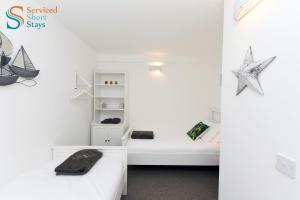 sypialnia z 2 łóżkami i rozgwiazdą na ścianie w obiekcie Two bedroom ground floor apartment near the beach w mieście Margate
