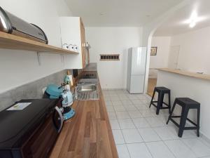 a kitchen with a counter and two stools in it at Résidence du Temple in Meaux