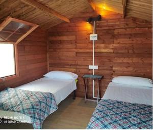 Habitación con 2 camas en una cabaña de madera en Camping Santa Clara, en Altea