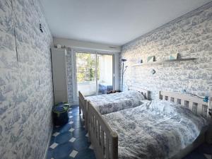 um quarto com 2 camas e uma parede de tijolos em Appartement bord de mer, Bénodet em Bénodet