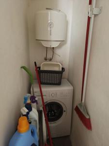 una pequeña lavandería con lavadora y escoba en Leccino Suite, en Matino