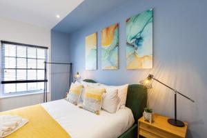 Schlafzimmer mit einem Bett mit blauer Wand in der Unterkunft At the level - (2 bed flat) in Brighton & Hove