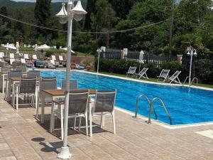 a table and chairs next to a swimming pool at Georgia's Apartments, Ipsos - Complex S in Ipsos