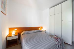 een slaapkamer met een bed met 2 nachtkastjes en 2 lampen bij Appartamenti Casa Dini in Marina di Campo