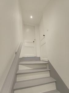 a staircase in a room with white walls and a door at Résidence du Temple in Meaux +34 photos