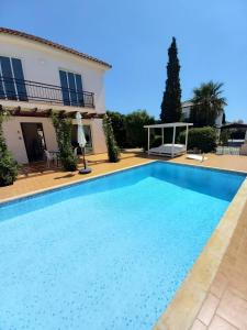 a large swimming pool in front of a house at Summer Breeze - Cheerful 2 bedroom villa with pool in Ayia Napa