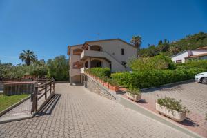 a house with a fence next to a driveway at Appartamenti Casa Dini in Marina di Campo