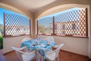 a table and chairs in a room with windows at Appartamenti Casa Dini in Marina di Campo