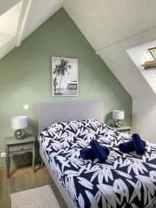 a bedroom with a bed with blue pillows on it at Appartement en duplex front de mer, Cap Coz in Fouesnant +14 photos