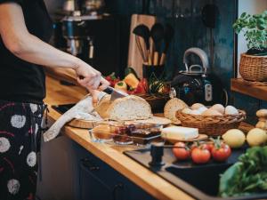 a person cutting bread on a counter with a knife at Owca za płotem in Witów