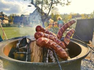 a bunch of sausages cooking on a grill at Owca za płotem in Witów +26 photos