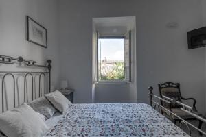 a bedroom with a bed and a window at La Semplicità del Borgo in Bagnoregio