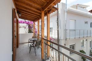 a balcony with a table and chairs on a building at Penelope Downtown in Skiathos