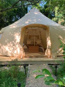 The Glade Bell tent في Sarcé: خيمة قماش فيها سرير