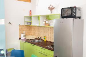 a kitchen with green cabinets and a white refrigerator at Smiley 2 in Novalja +1 photo