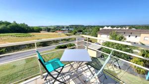 een tafel en stoelen op een balkon met uitzicht op een straat bij Appartement Le Moulin in Jonzac