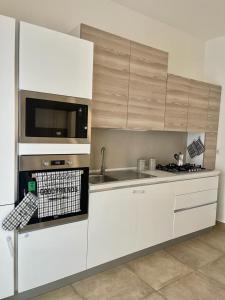 una cucina con armadi bianchi e piano cottura di holiday home a Matino