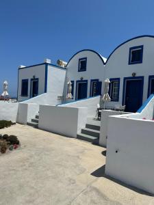 a row of white buildings with stairs and tables at Hotel Paradisos Oia in Oia