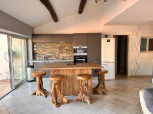 a kitchen with a wooden table and stools at Dans Baptiste traditionnellle appartement de la plage et terrasse Balli in Rayol-Canadel-sur-Mer