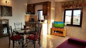 cocina y comedor con mesa y TV en Villa Linet, en Funtana