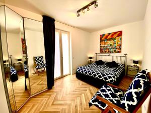 a bedroom with a black and white bed and a mirror at Appartamento Alice Silver in Bardolino
