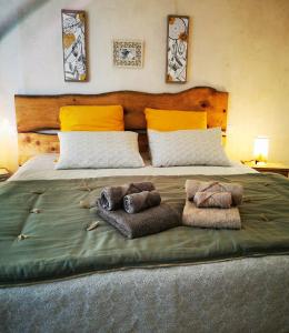 a large bed with two blankets and pillows on it at chambres d hotes Ysalice in Merlas