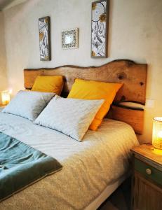um quarto com uma cama com almofadas laranja e branca em chambres d hotes Ysalice em Merlas