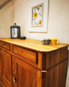 um armário de madeira com duas xícaras em cima em chambres d hotes Ysalice em Merlas