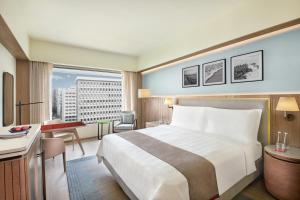 a hotel room with a large bed and a desk at Trident Nariman Point in Mumbai