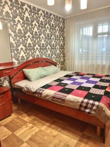ein Schlafzimmer mit einem Bett mit einer karierten Decke in der Unterkunft Трьохкімнатна квартира неподалік центру in Ternopil